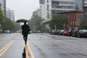 A woman walks down the street during a rainstorm in DC