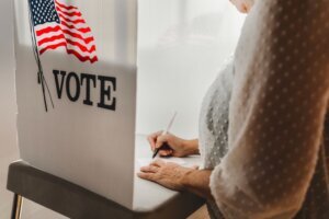 Woman voting in a booth privacy participation decision.