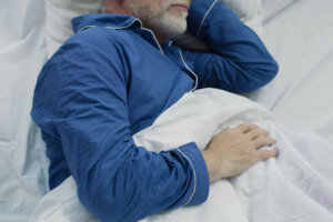 Old man sleeping in bed in the morning