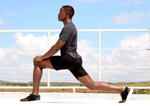 Young Fit Man Stretching Outside in Forward Lunge Position