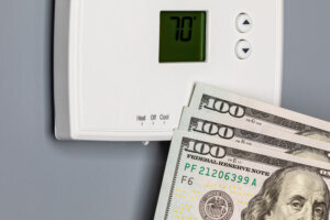 Thermostat for home furnace and air conditioner. Utility bill savings, energy cost and conservation concept
