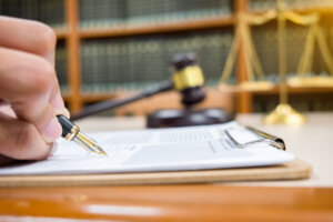 Lawyer Detail of a judge sitting at his desk, studying new laws and legislation and taking notes. Selective focus