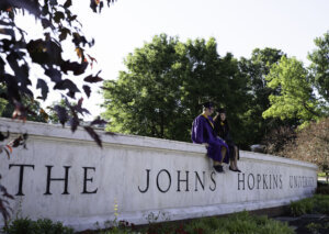 A couple of graduates taking photos at the Johns Hopkins University campus