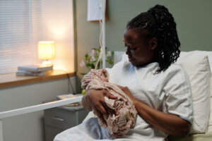 Cradling Newborn in Hospital Bed with Soft Lighting