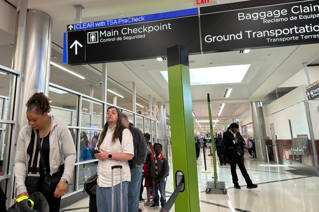Passengers wait outside a Transportation Security Administration checkpoint