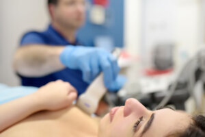 Doctor examines a woman breasts and lymph nodes using ultrasound