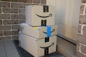 Amazon prime boxes and envelopes delivered to a front door of residential building