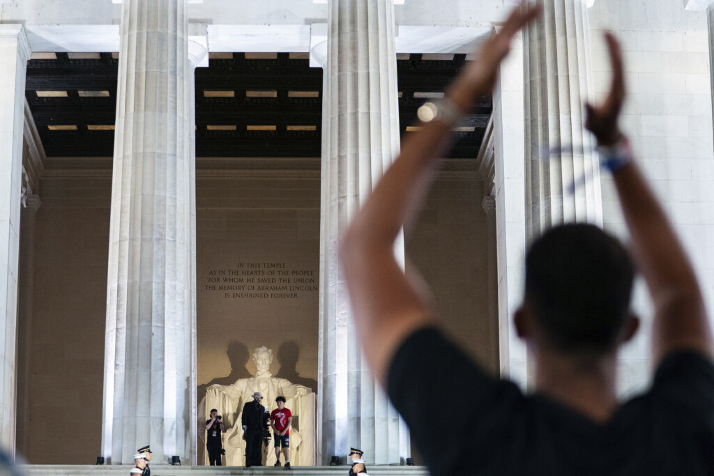 An audience members cheers as UFC heavyweight fighter Josh Hokit enters a UFC news conference at the Lincoln Memorial, ahead of Sunday's fight on the South Lawn of the White House, Friday, June 12, 2026, in Washington. (AP Photo/Allison Robbert)