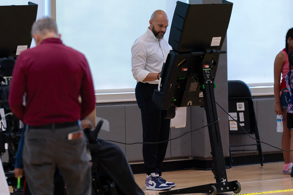 D.C. Council member Robert White Jr., uses an electronic voting machine to cast his vote during the D.C. primary election at Shepherd Elementary, Tuesday, June 16, 2026, in Washington. (AP Photo/Jose Luis Magana)