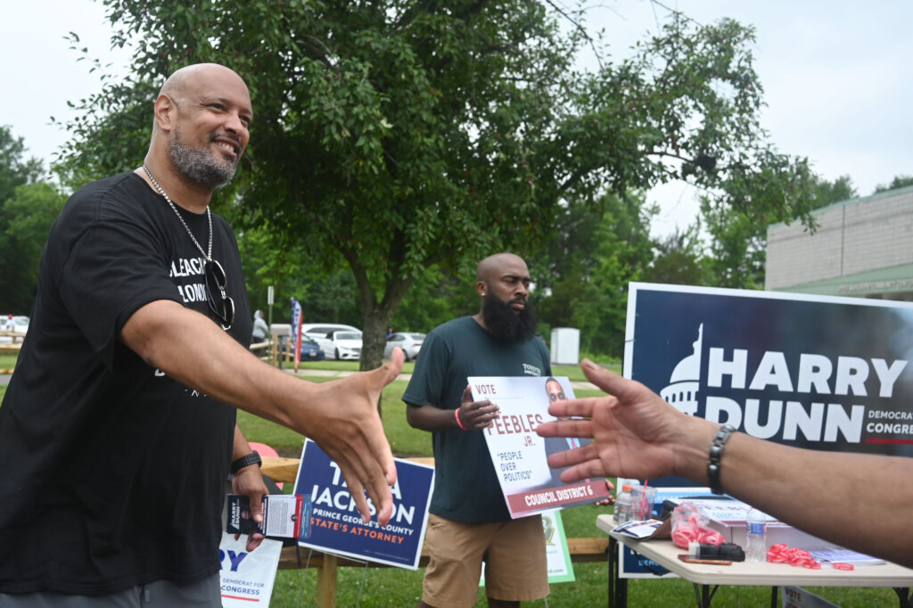 Harry Dunn, former U.S. Capitol Police officer and candidate for U.S. Congress greets a voter Tuesday, June 23, 2026, in Upper Marlboro, Md. (AP Photo/Gail Burton)