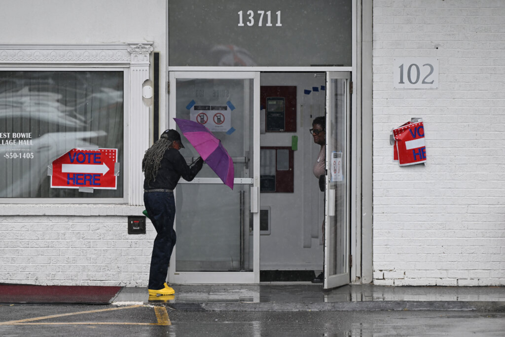 A woman braves the rain to vote at the West Bowie Village Hall Tuesday, June 23, 2026, in Bowie, Md. (AP Photo/Gail Burton)