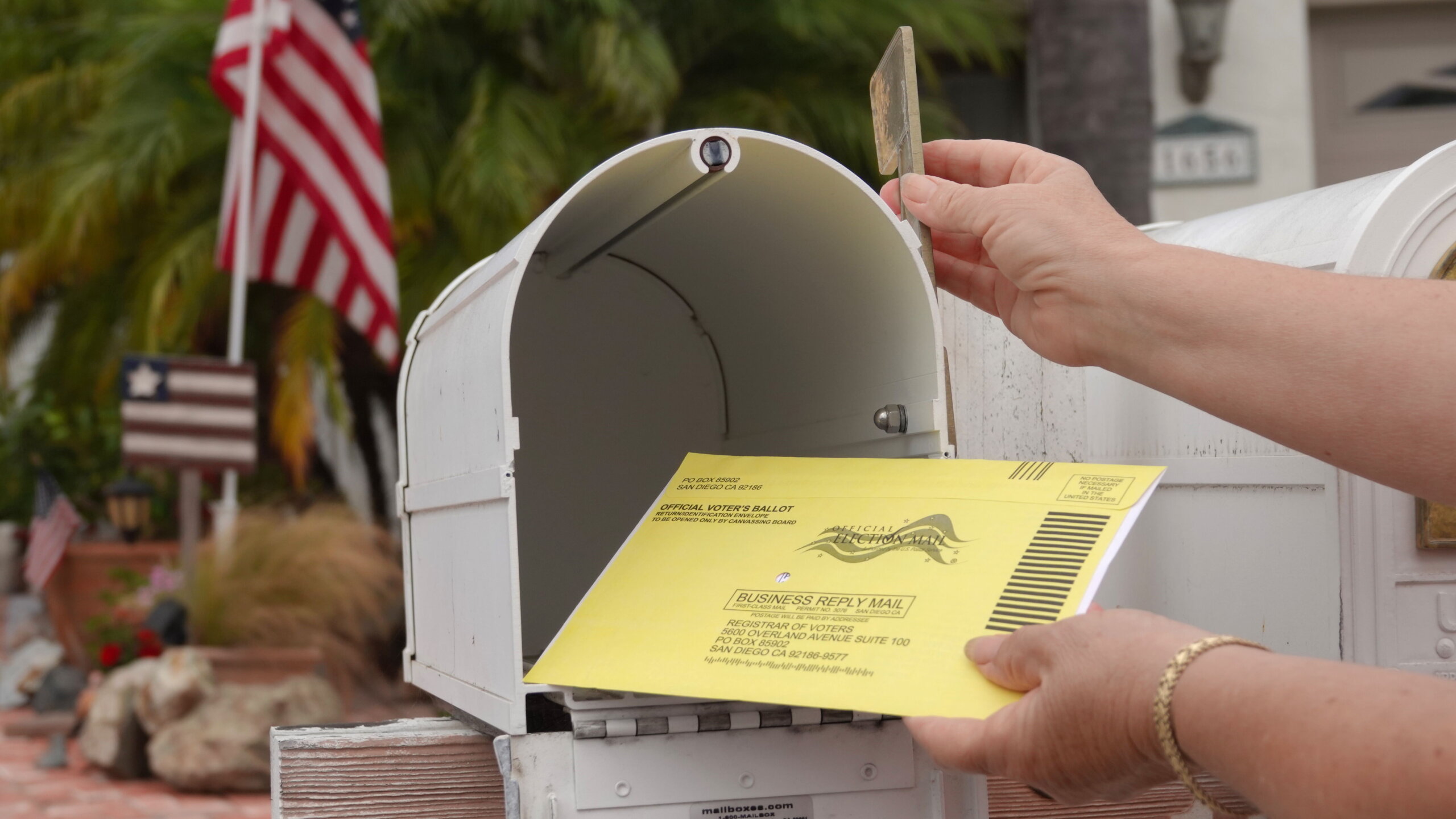 Woman puts US mail in ballot into mailbox