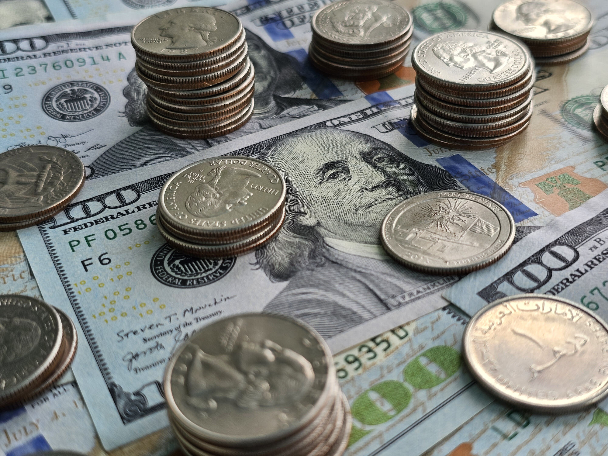 Stacks of coins and paper money spread out on a table