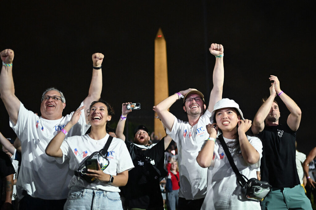 Fans react as they watch the "UFC Freedom 250" mixed martial arts event on The Ellipse, south of the White House in Washington, DC, in the early morning hours of June 15, 2026. (Photo by Alex WROBLEWSKI / AFP via Getty Images)