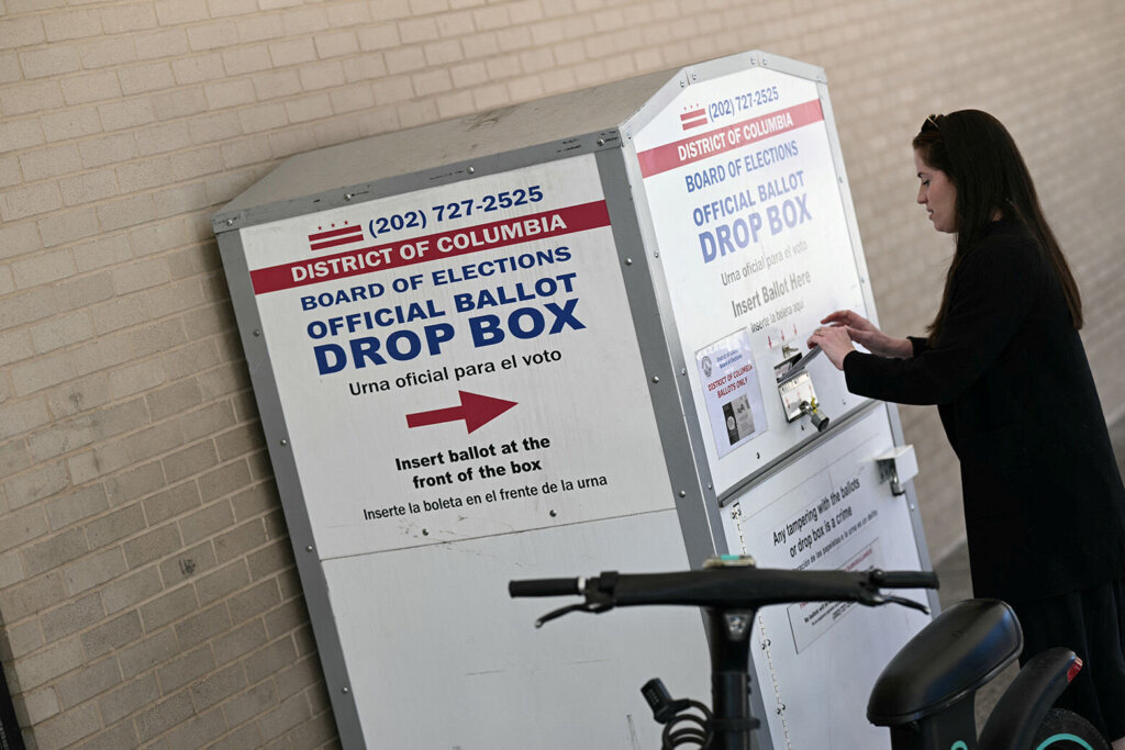 A person drops her ballot in a drop box at a polling place at the Martin Luther King Jr. Memorial Library during the D.C. primary elections on June 16, 2026, in Washington, D.C. (Photo by Brendan SMIALOWSKI/AFP via Getty Images)