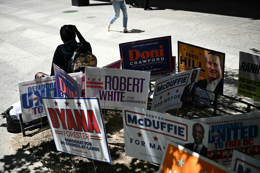 Campaign signs are seen at a polling place at Martin Luther King Jr. Memorial Library during the D.C. primary elections on June 16, 2026, in Washington, D.C. (Photo by Brendan SMIALOWSKI/AFP via Getty Images)