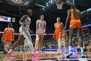 Michaela Onyenwere (12) and Lauren Betts (51) of the Washington Mystics race to congratulate teammate Sonia Citron,