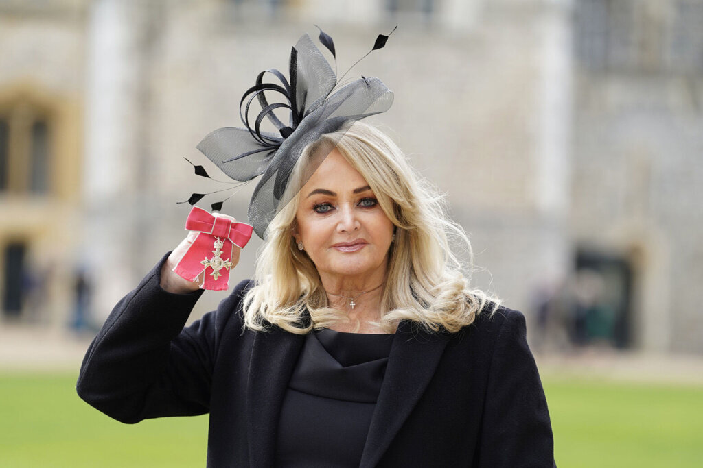 Welsh singer Bonnie Tyler poses with her MBE after being made a Member of the Order of the British Empire by the Prince of Wales during an investiture ceremony at Windsor Castle, Berkshire, England Wednesday Feb. 1, 2023. Bonnie Tyler, the gravelly voiced, Grammy-nominated Welsh pop star whose 1983 chart-topping power ballad “Total Eclipse of the Heart” enchanted succeeding generations with its bombastic charms during solar and lunar eclipses, has died. She was 75. (Andrew Matthews/Pool via AP)