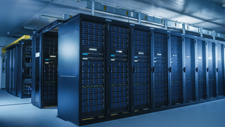 Shot of Modern Data Center With Multiple Rows of Operational Server Racks. Modern High Tech Database Super Computer Clean Room.