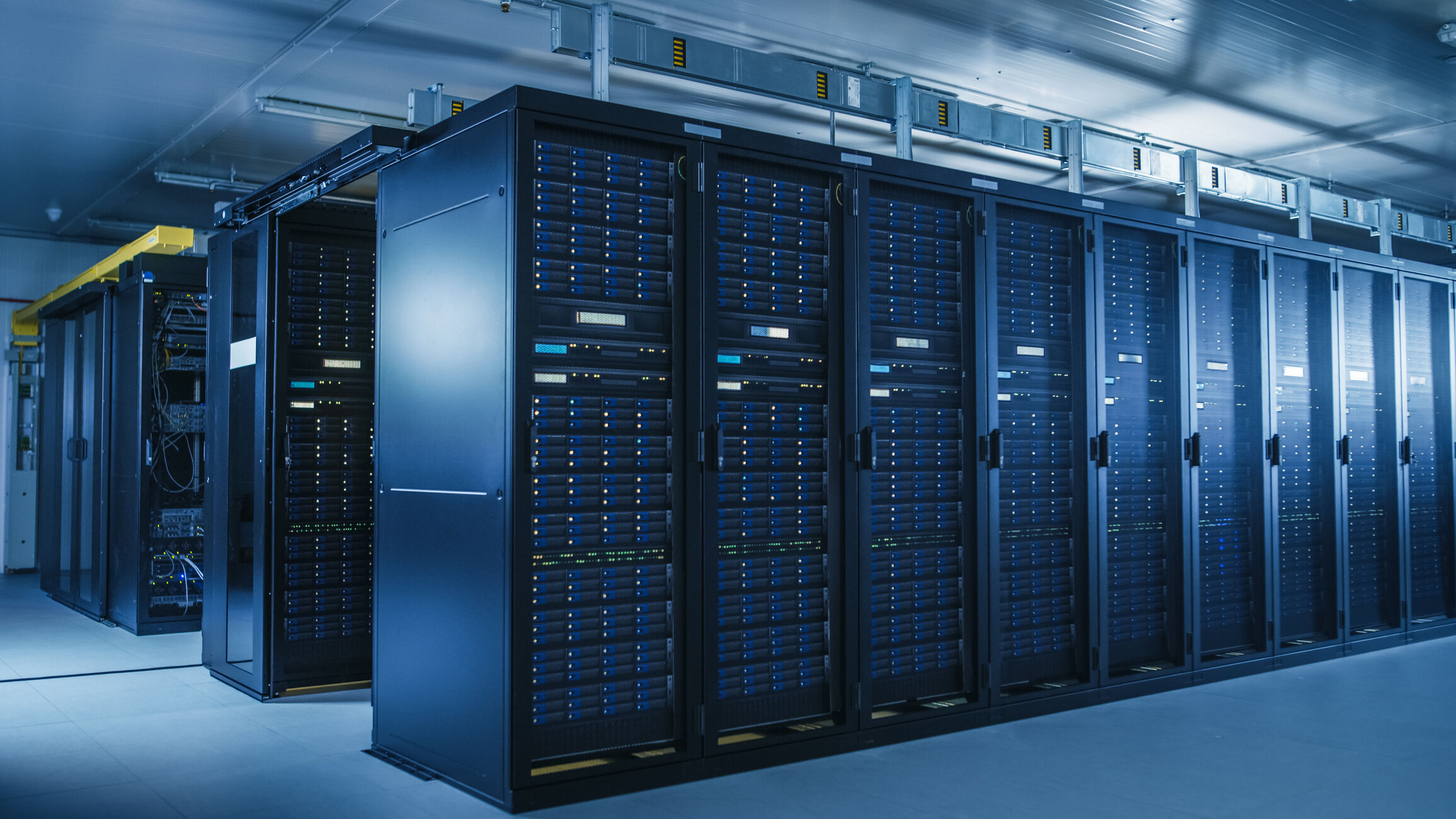 Shot of Modern Data Center With Multiple Rows of Operational Server Racks. Modern High Tech Database Super Computer Clean Room.