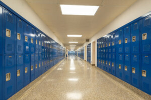 Empty school hallway with royal blue metal lockers along both sides