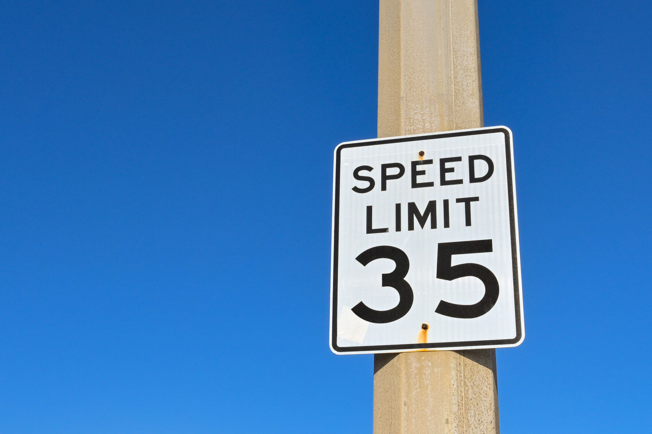 Speed limit sign against a blue sky