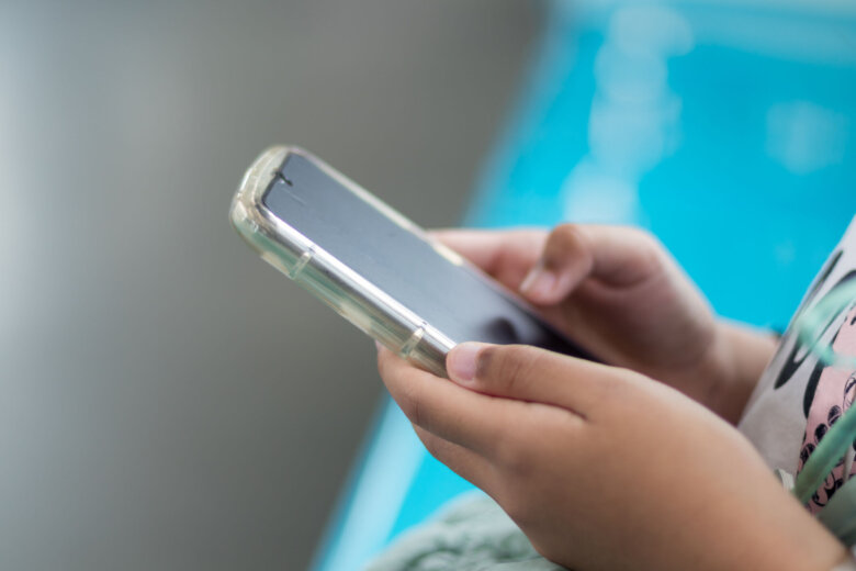 Close up view of a little girl's hand using a smartphone