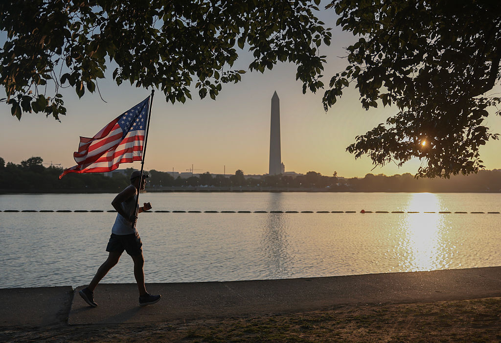 Pete Folch carries an American flag during a morning run along the Tidal Basin
