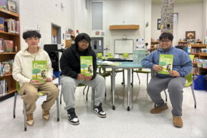 Oakton High School students hold their new book on financial literacy