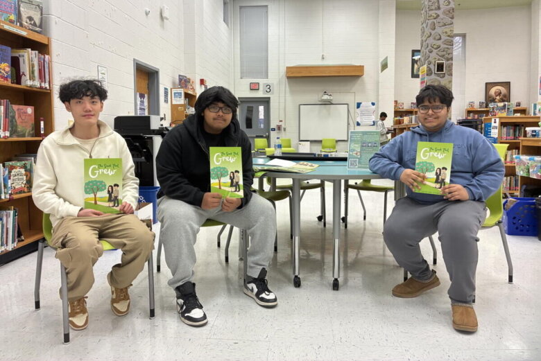 Oakton High School students hold their new book on financial literacy