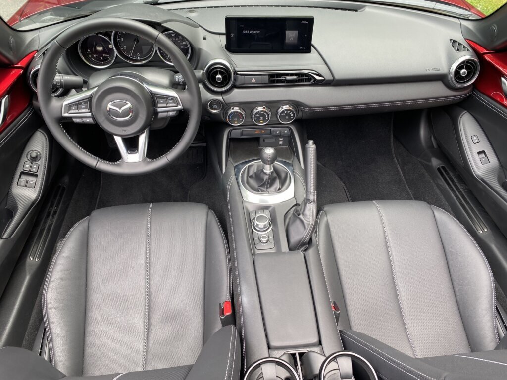 There’s no traditional glove box, just a lockable cubby tucked between the seat backs. Door pockets are nowhere to be found. (WTOP/John Aaron)