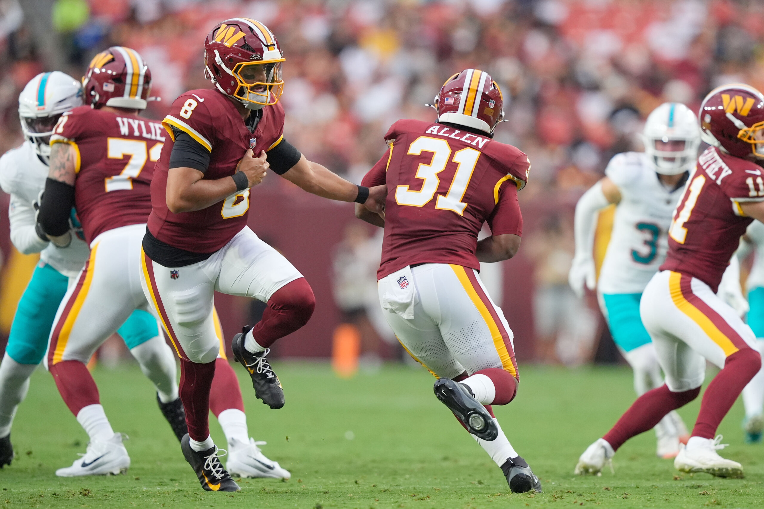 Washington Commanders quarterback Marcus Mariota (8) hands the ball to running back Kaytron Allen (31)