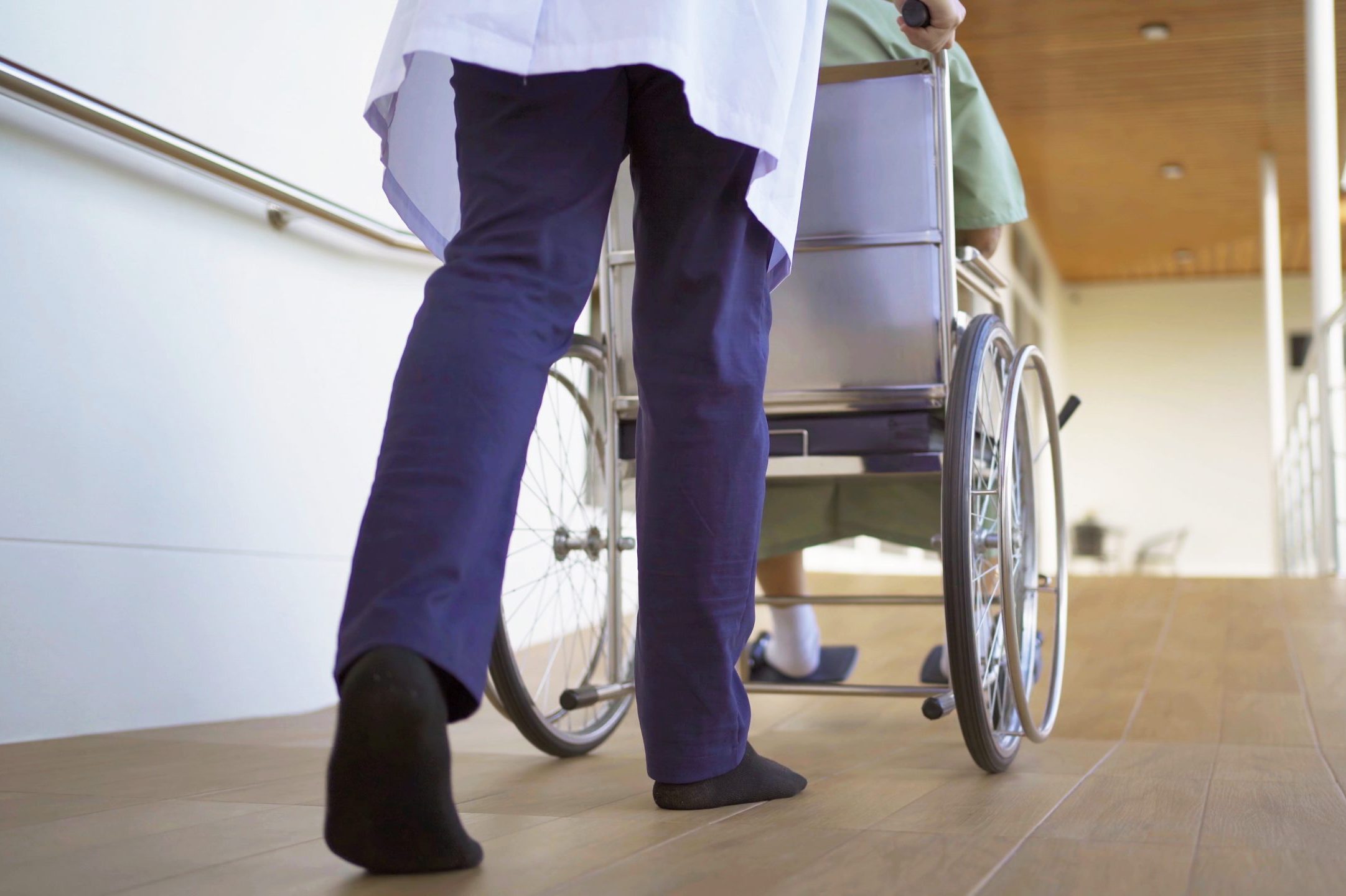 An elderly Asian patient and a doctor using a wheelchair